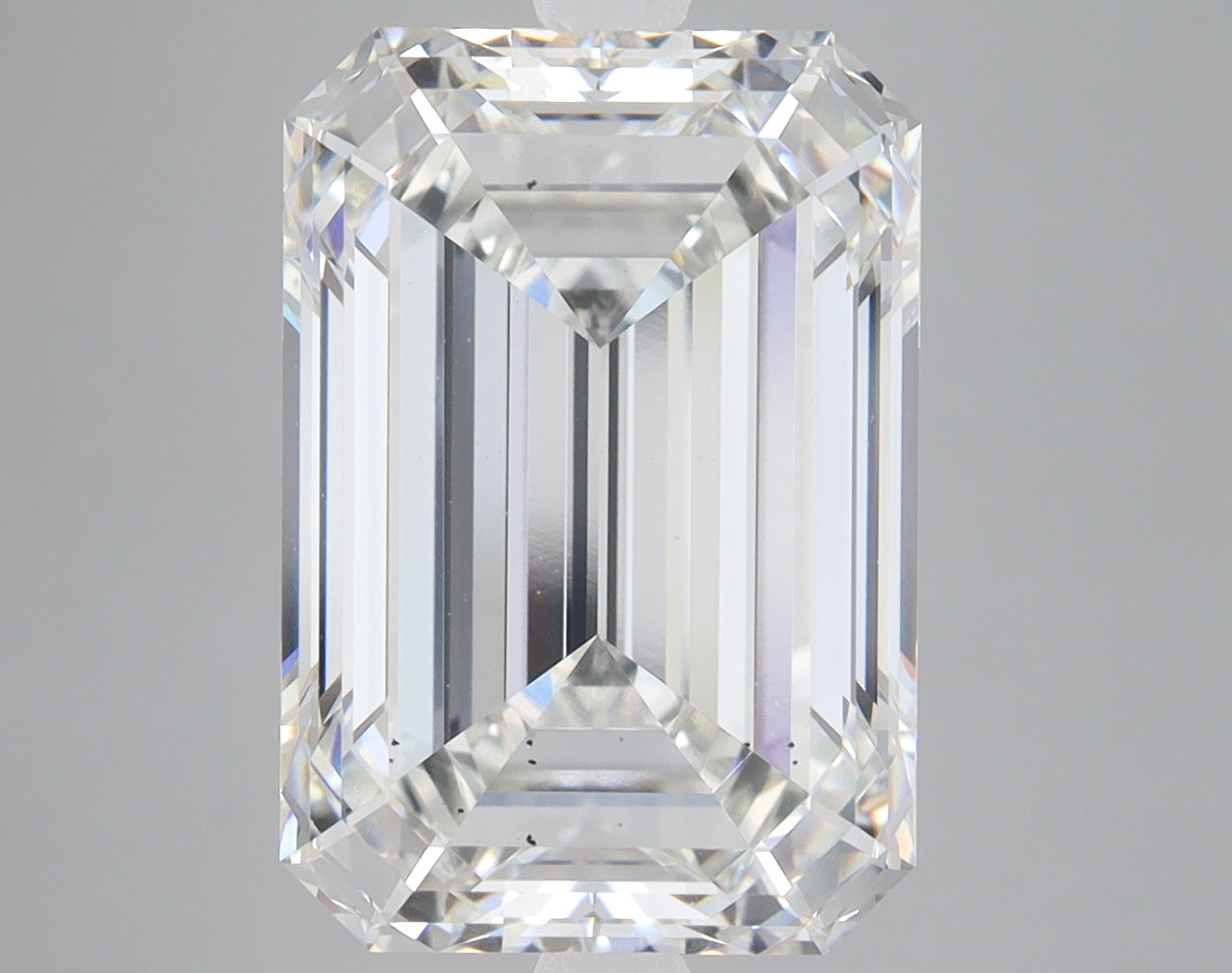 Emerald-cut lab-grown diamond with faceted surfaces and clear transparency, displaying light refraction with subtle color ton