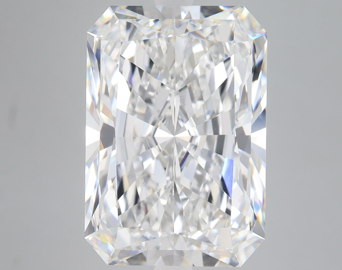 Radiant cut lab grown diamond with faceted surfaces reflecting light, displayed against neutral background.