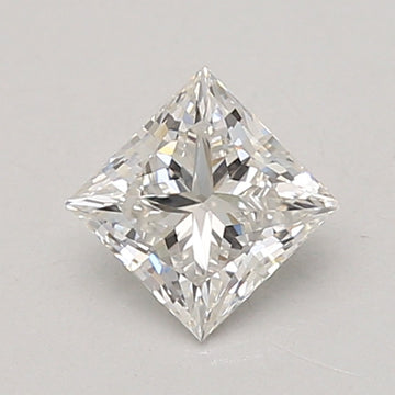 Clear princess-cut diamond with faceted surfaces and reflective light patterns on gray background.