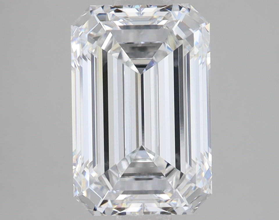 Clear emerald-cut lab-grown diamond with faceted sides and light reflections on neutral gray background.