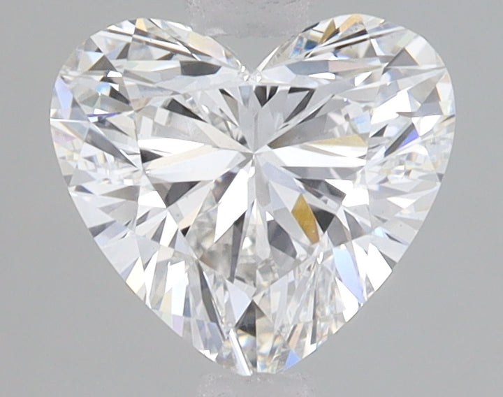 Heart-shaped lab-grown diamond with brilliant faceting and light refraction on neutral gray background.
