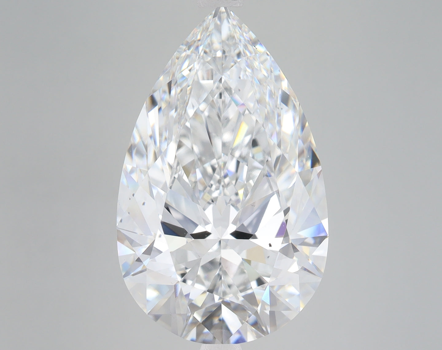 Pear-shaped lab-grown diamond with faceted surfaces reflecting white and colored light against neutral background.