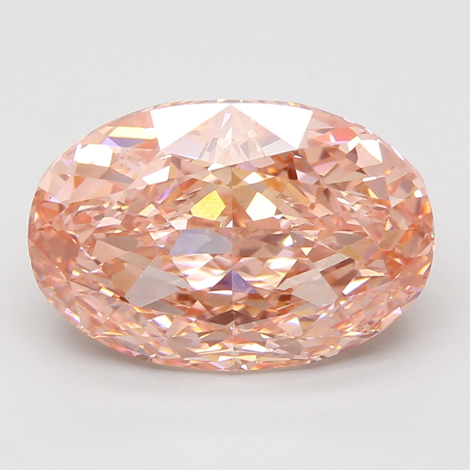 Oval-cut lab-grown diamond with faceted surface and light peachy-pink coloration on neutral background.