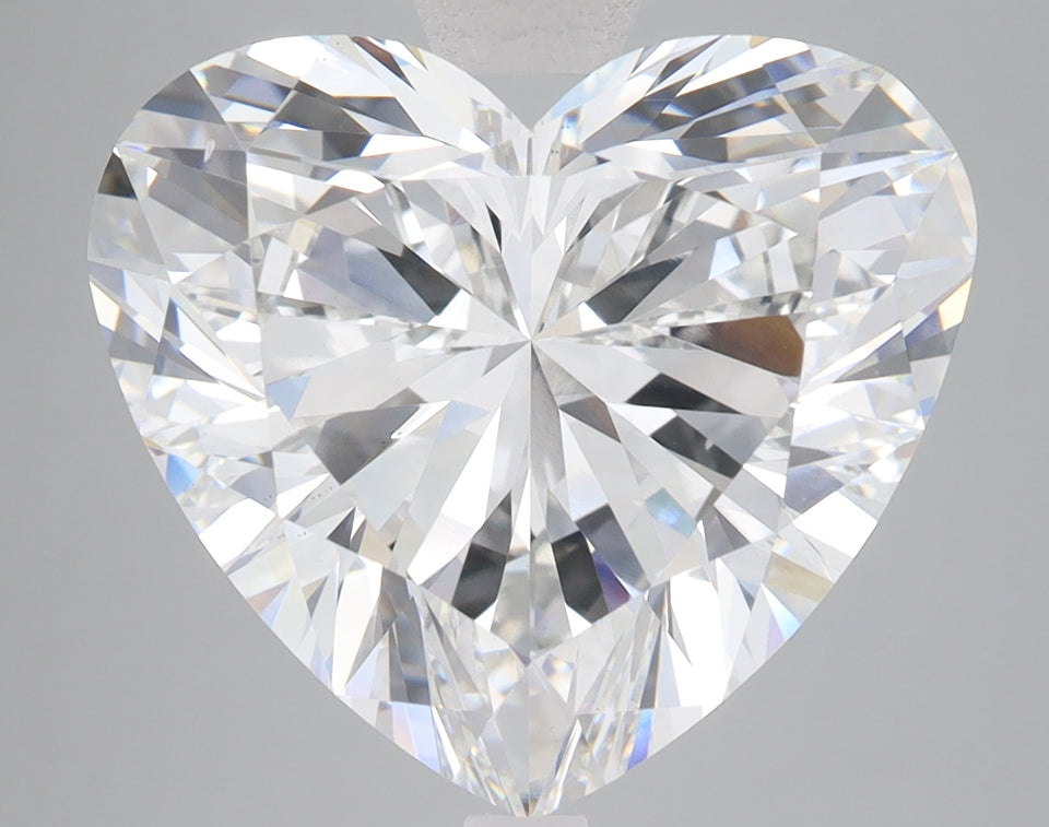 Heart-shaped lab-grown diamond with brilliant faceting and clear appearance on gray background.