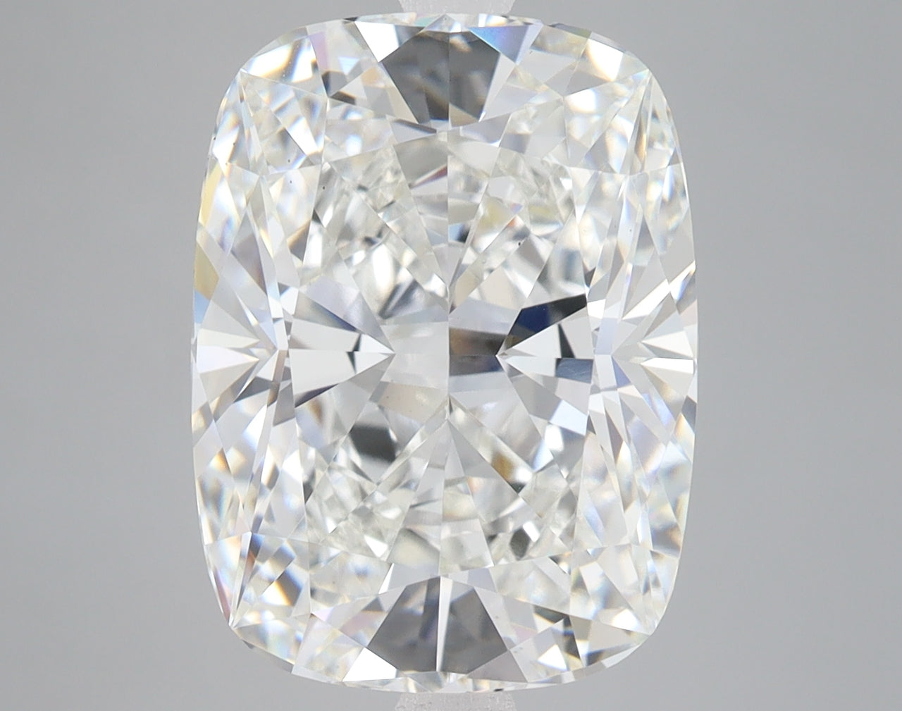 Cushion-cut lab-grown diamond with faceted surfaces reflecting light, displayed against a neutral gray background.