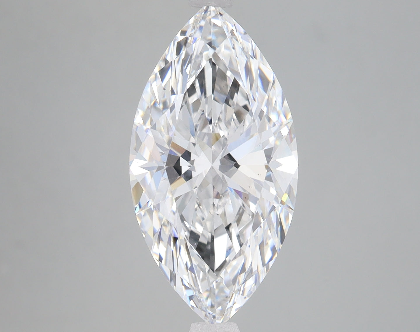 Marquise-cut clear lab-grown diamond with faceted surfaces and internal light reflections displayed against neutral backgroun