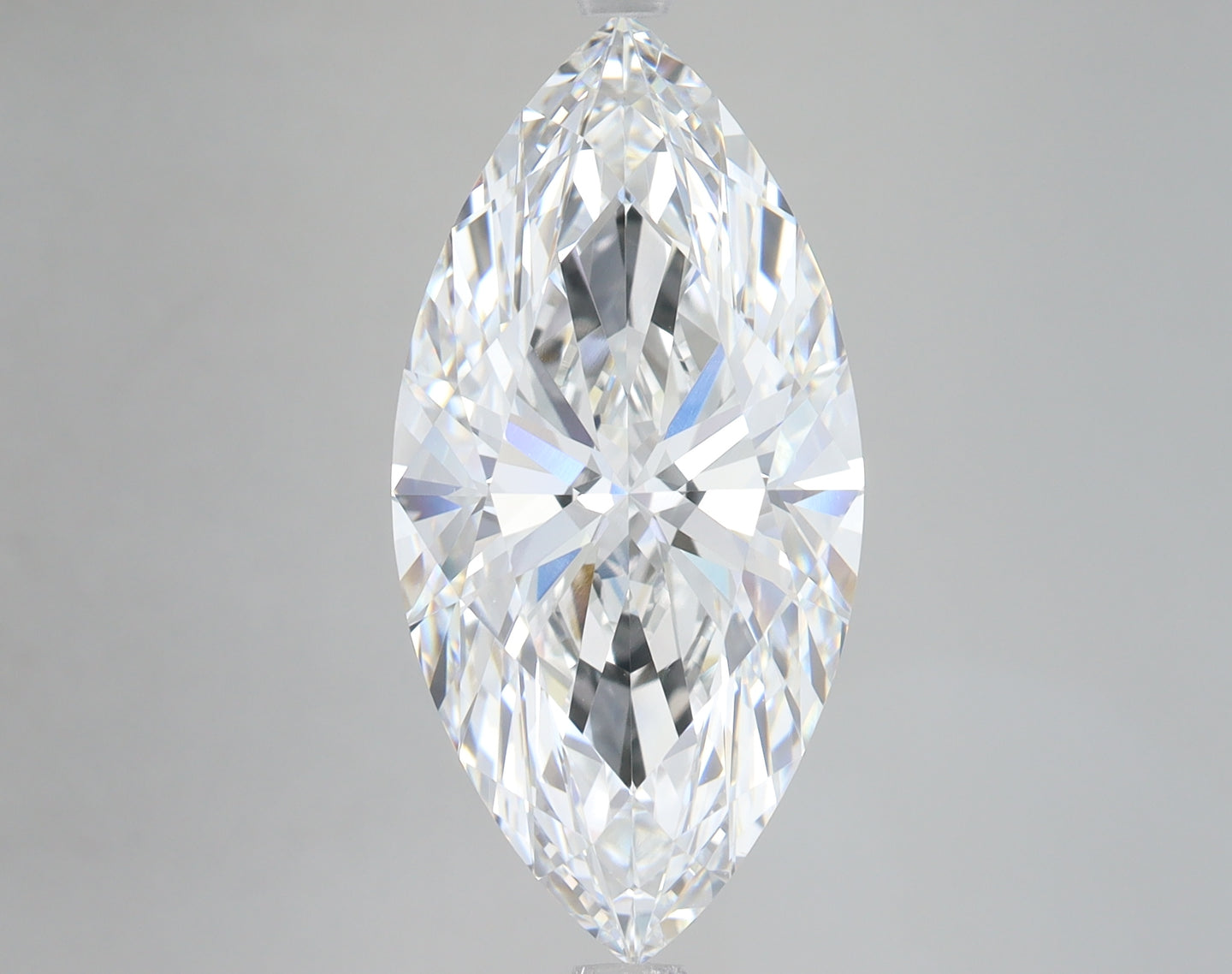 Marquise-cut loose diamond with faceted surfaces reflecting light, displayed against a neutral gray background.
