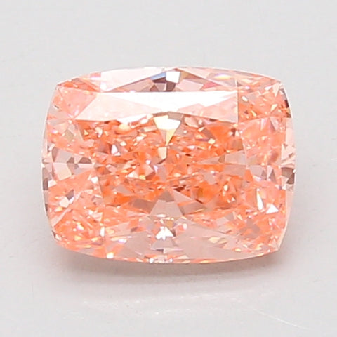 Cushion-cut lab-grown diamond with peachy-pink hue and faceted surface, displayed against white background.
