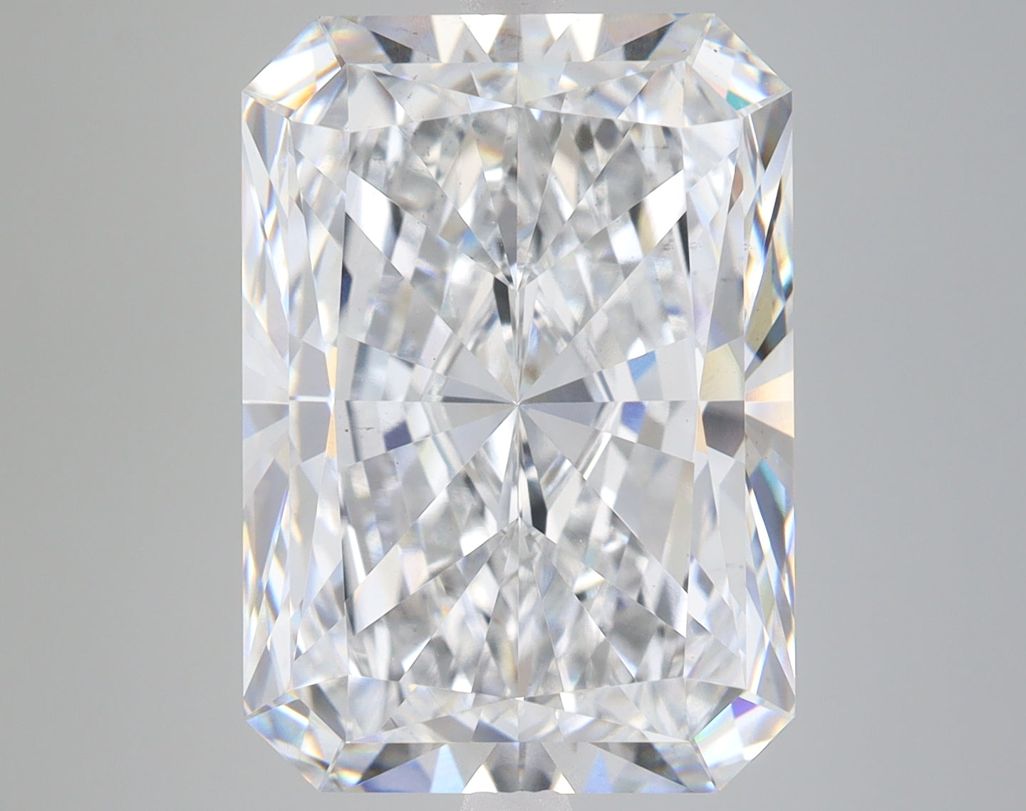 Radiant cut loose diamond with clear faceted surfaces and light reflections on gray background.