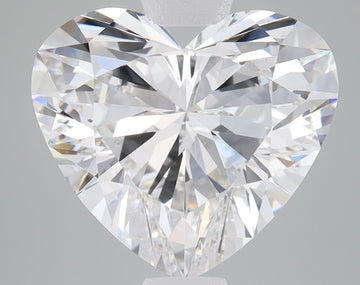 Heart-shaped faceted clear diamond with reflective surfaces on gray background.