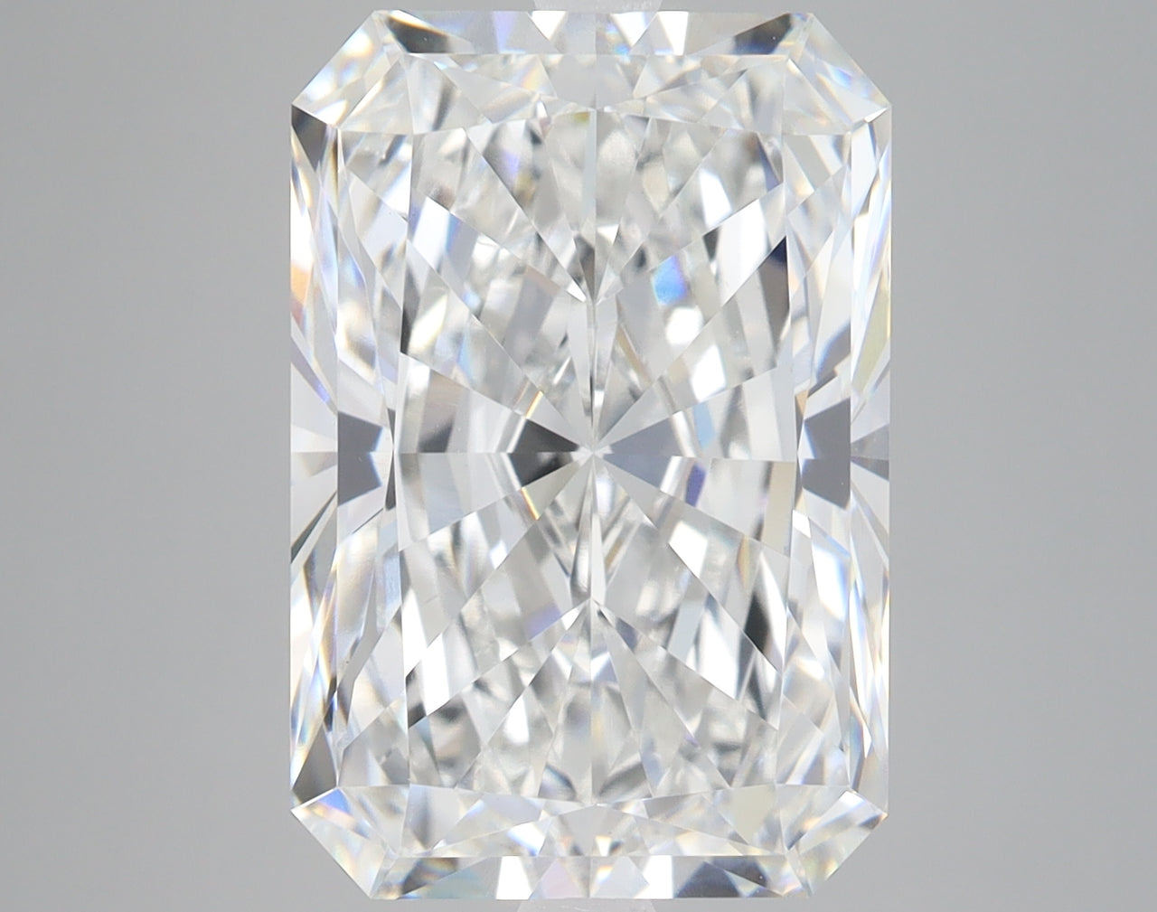 Clear radiant-cut loose diamond with brilliant faceting and light reflections on neutral background.