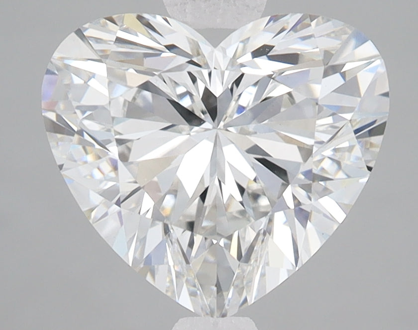 Heart-shaped lab-grown diamond with faceted surface reflecting light, displayed against neutral gray background.