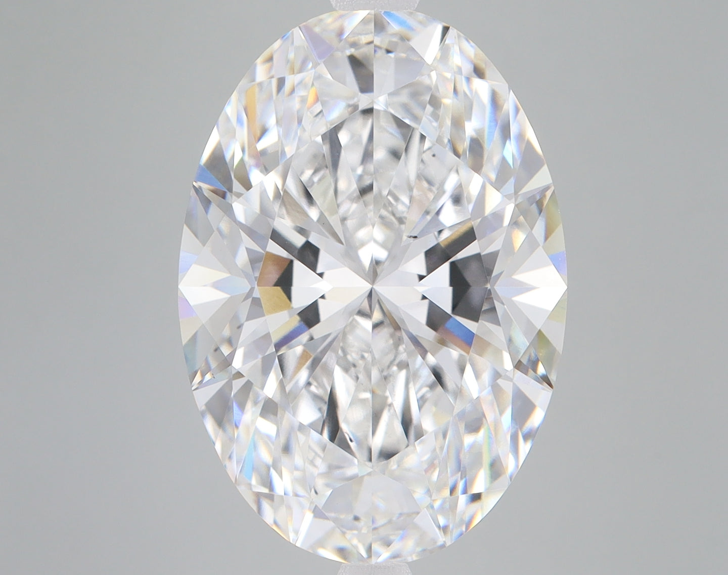 Oval-cut lab-grown diamond with faceted surfaces reflecting light, displaying clear transparency and colorless appearance aga