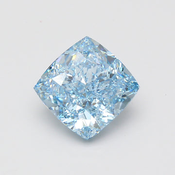 Cushion cut lab grown diamond with light blue tint, faceted surfaces reflecting light, displayed against neutral background.