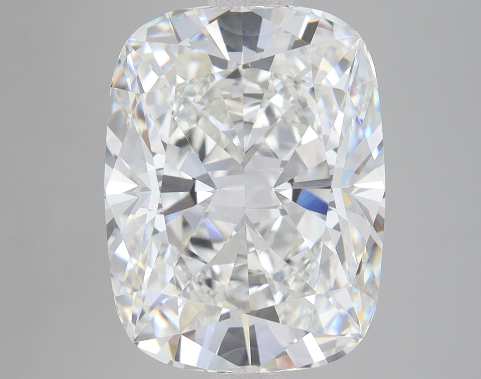 Cushion-cut lab-grown diamond with faceted surfaces reflecting light, displayed against a neutral gray background.