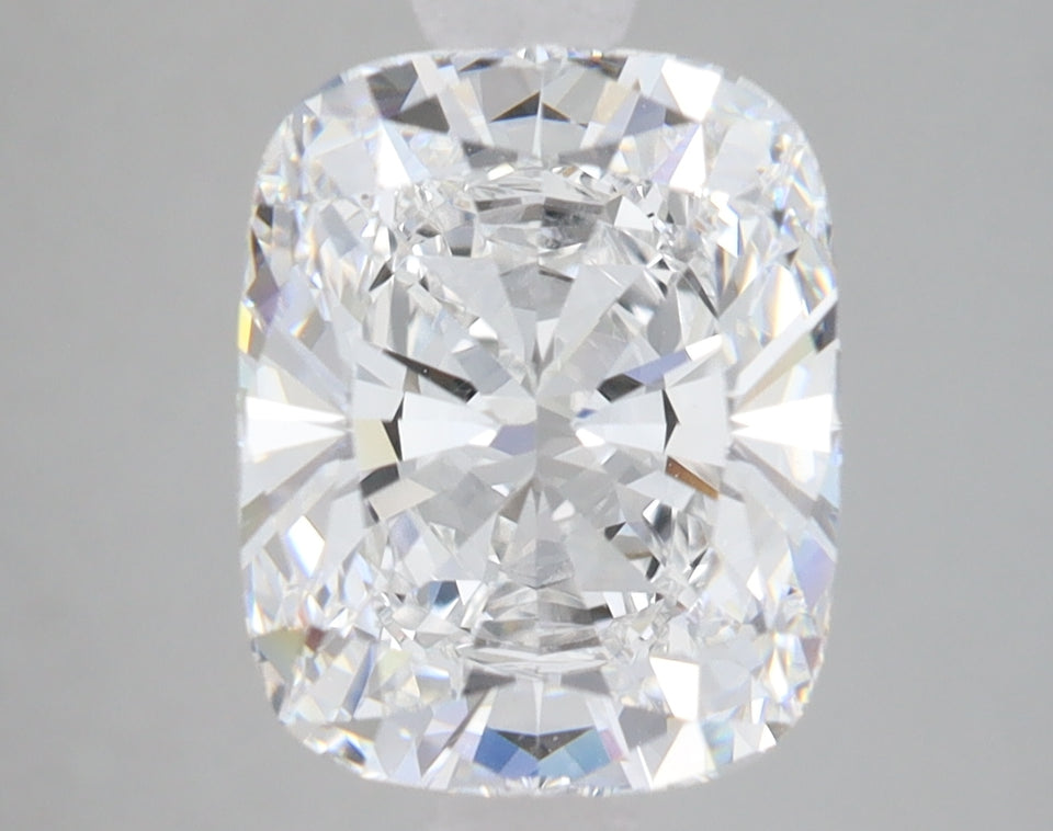 Cushion cut loose diamond with clear faceting and light refraction on gray background.