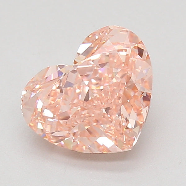 Heart-shaped lab-grown diamond with faceted surfaces and light peachy-pink coloring, displayed against a neutral background.