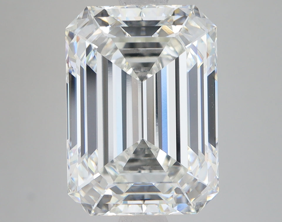 Clear emerald-cut lab-grown diamond with faceted surfaces and light reflections on neutral background.