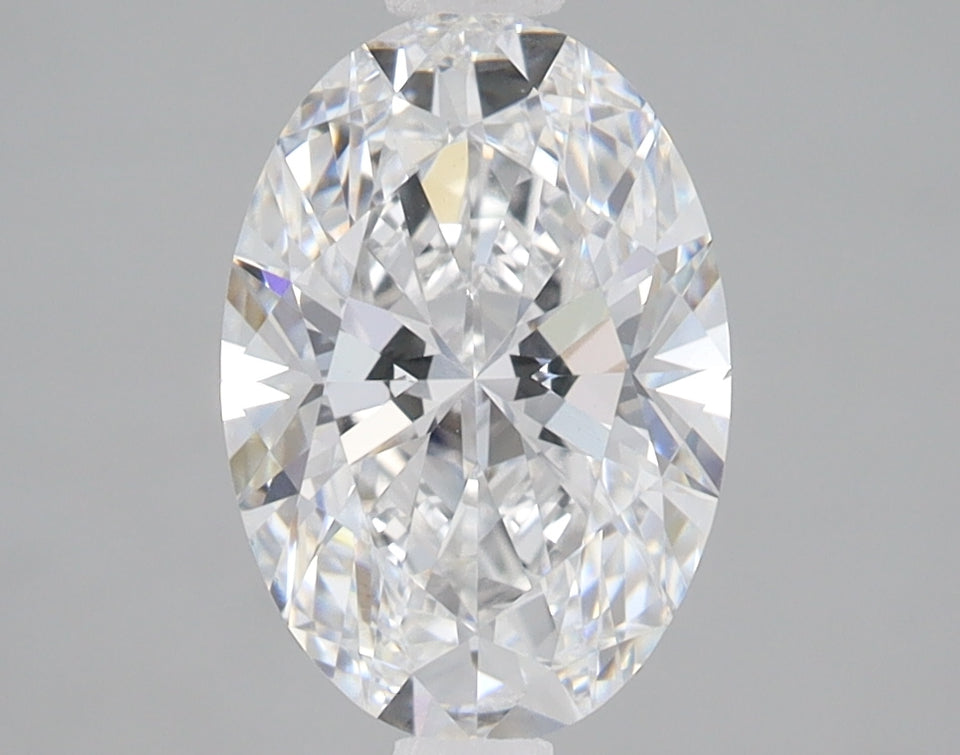 Clear oval-cut diamond with faceted surface and multiple light reflections against gray background.