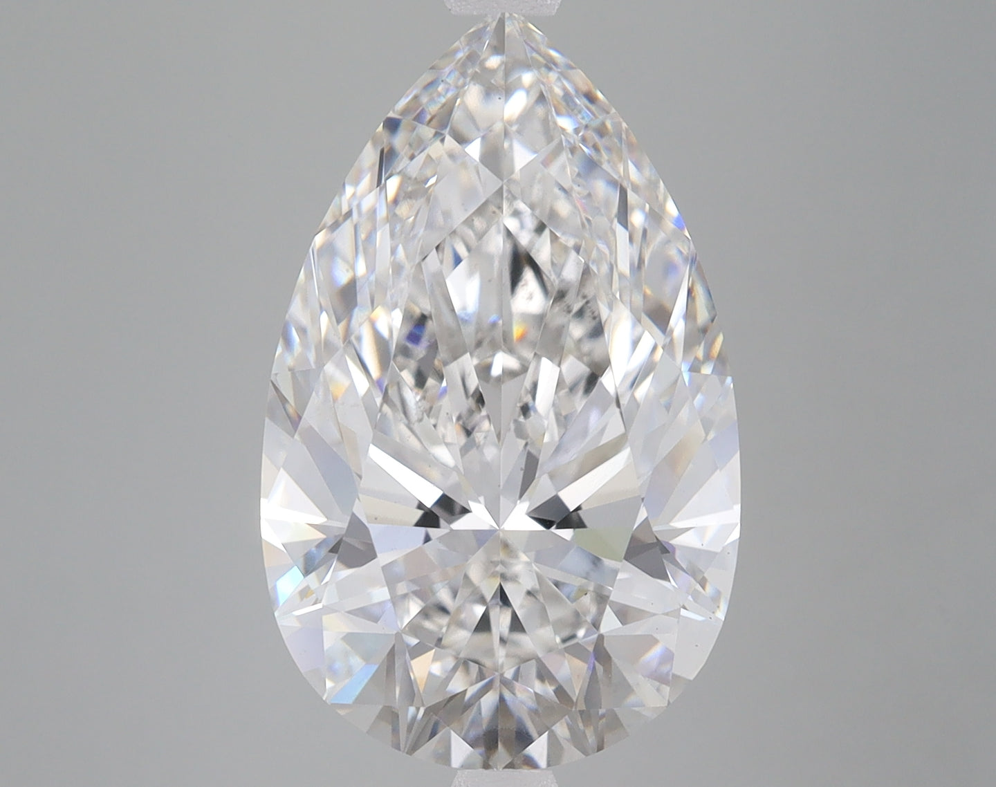 Pear-shaped clear lab-grown diamond with faceted cuts displaying light refraction on gray background.