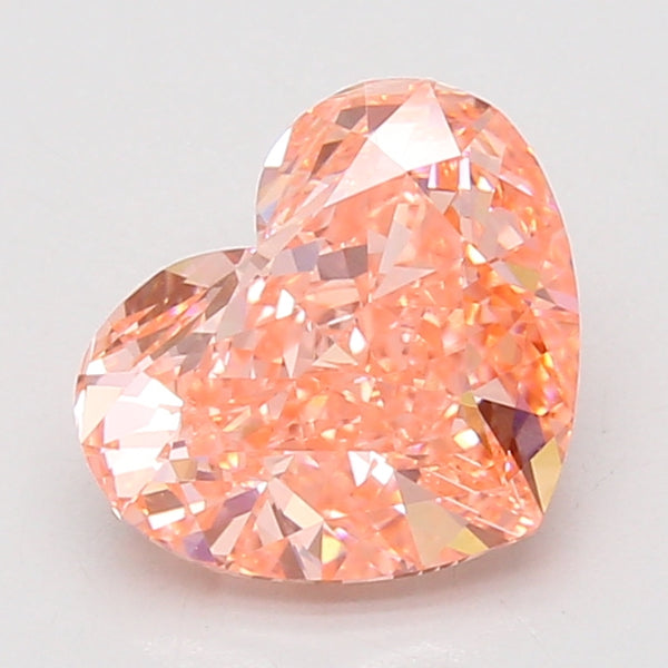 Heart-shaped lab-grown diamond with faceted surfaces displaying peach and pink tones, certified loose stone.