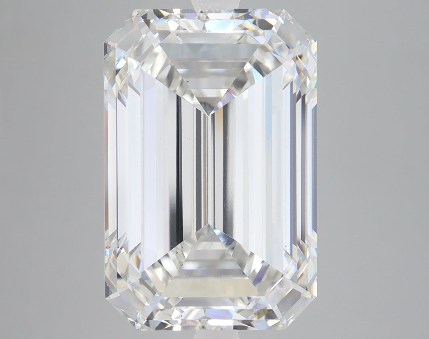 Emerald-cut lab-grown diamond loose stone with faceted surfaces and light reflections on neutral background.