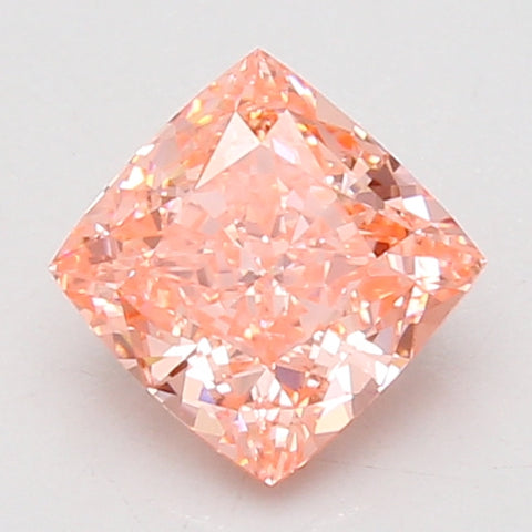 Cushion cut lab grown diamond with pink-orange hue and faceted surface on light gray background.