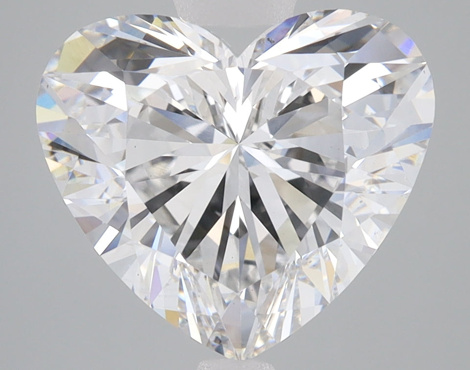 Heart-shaped lab-grown diamond with brilliant faceting and light refraction on neutral gray background.