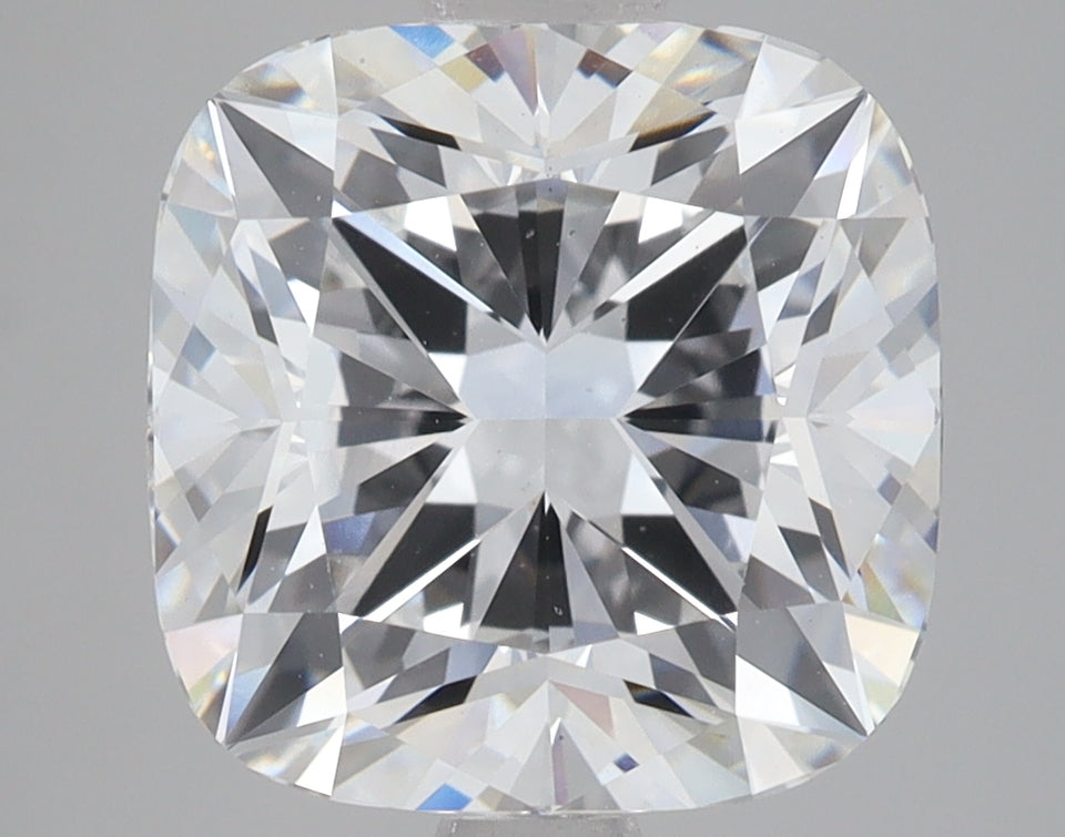 Cushion cut lab grown diamond with faceted surface reflecting light, displayed against neutral gray background.