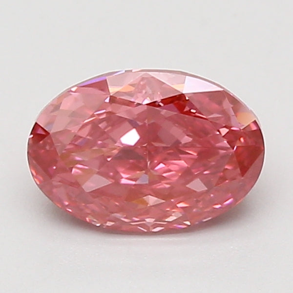 Oval faceted lab-grown diamond with pink hue and multiple reflective surfaces on white background.