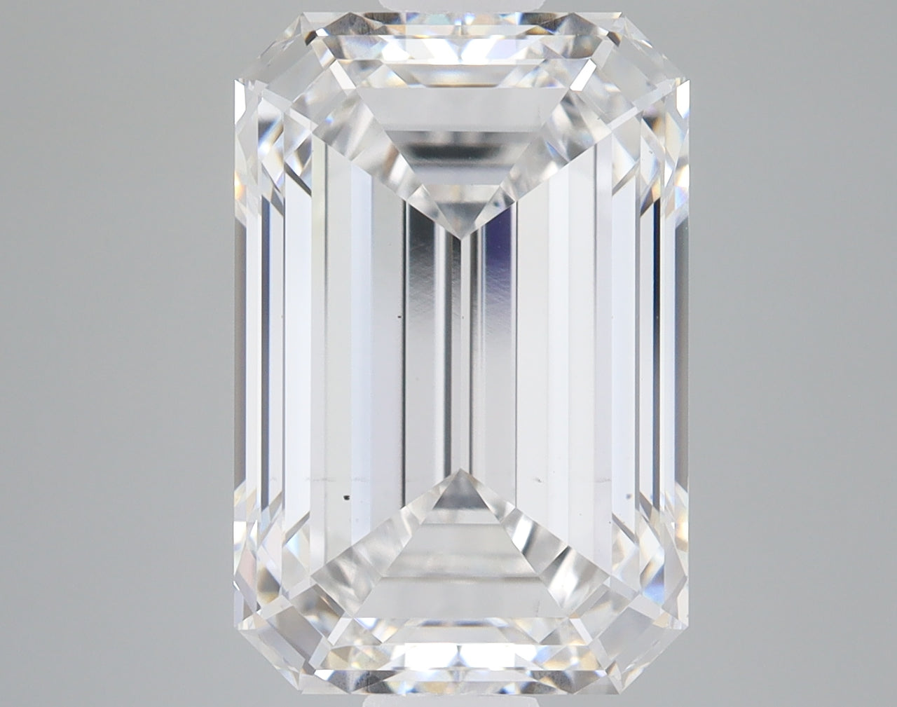 Emerald-cut lab-grown diamond with faceted surfaces displaying light refraction, approximately 5.73 carats.
