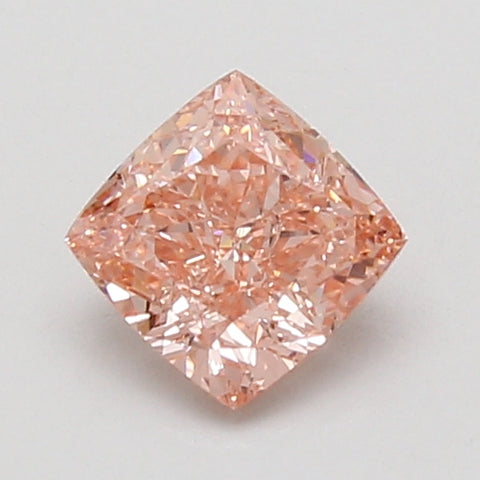 Cushion-cut lab-grown diamond with peachy-pink hue and faceted surface on neutral background.