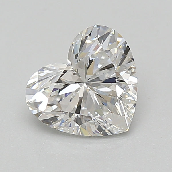 Heart-shaped transparent diamond with faceted surface and light reflections on gray background.