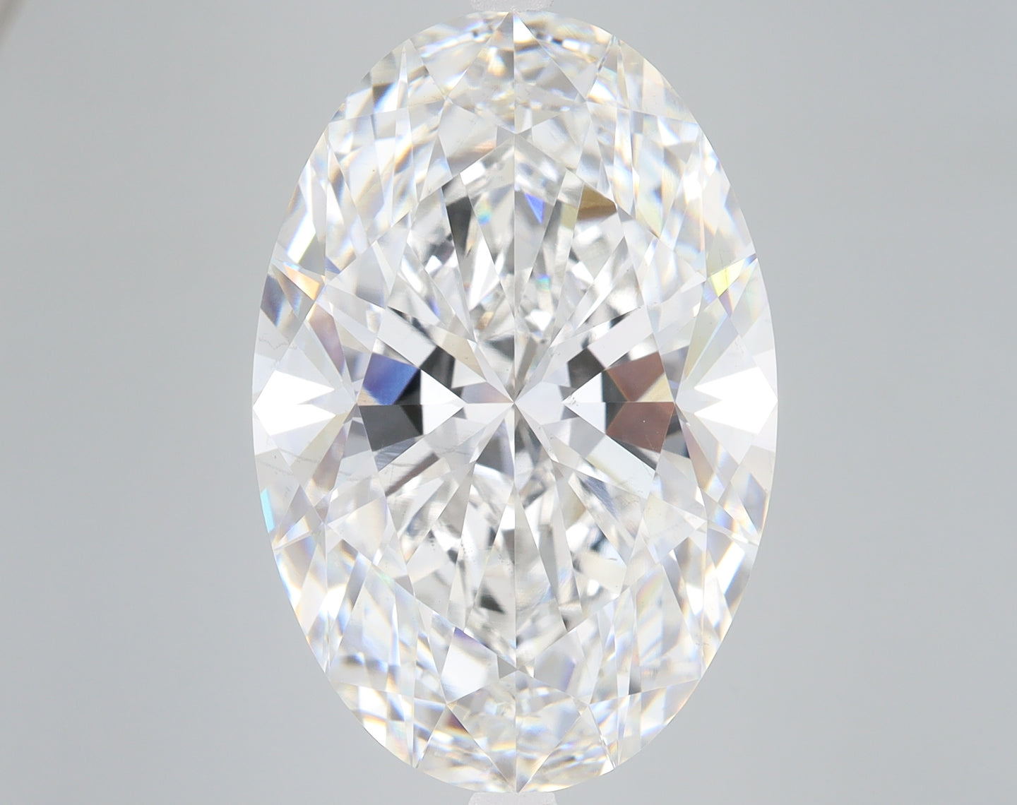 Oval-cut lab-grown diamond with faceted surface displaying light refraction and clarity against neutral background.