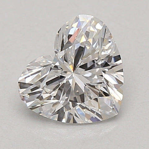 Heart-shaped lab-grown diamond with faceted surfaces and light reflection, displayed on neutral background.