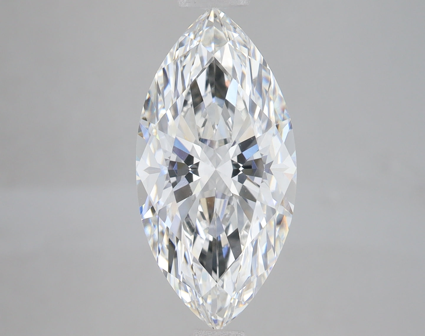 Marquise cut lab grown diamond with faceted surface reflecting light, displayed against neutral gray background.