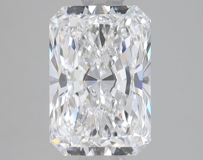 Clear radiant-cut diamond with faceted surfaces and light reflection on neutral background.