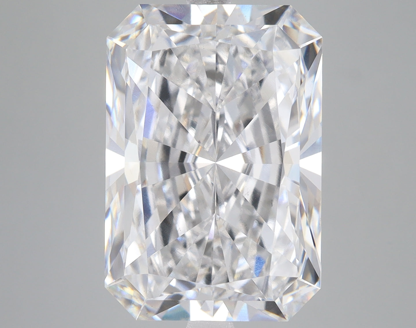 Radiant cut lab grown diamond with clear faceted surfaces and light refraction, displayed against neutral background.