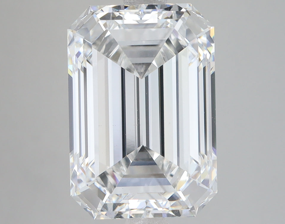 Colorless emerald-cut lab-grown diamond with faceted surfaces and light reflections on neutral background.