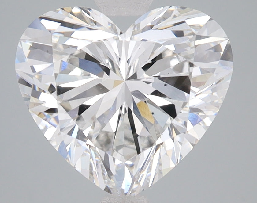 Heart-shaped clear lab-grown diamond with multiple facets reflecting light against gray background.