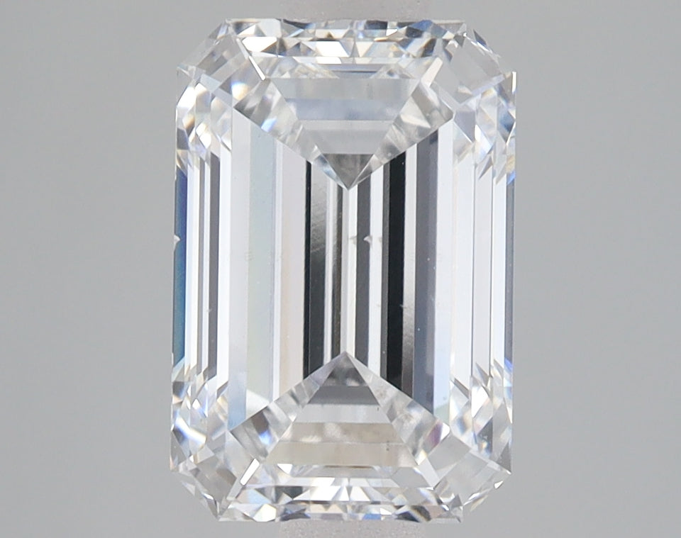 Emerald cut lab-grown diamond with clear facets and reflective surfaces on neutral background.