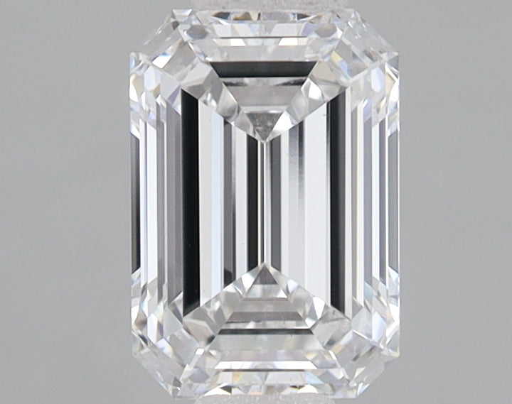 Clear emerald-cut lab-grown diamond with faceted edges and reflective surfaces on gray background.