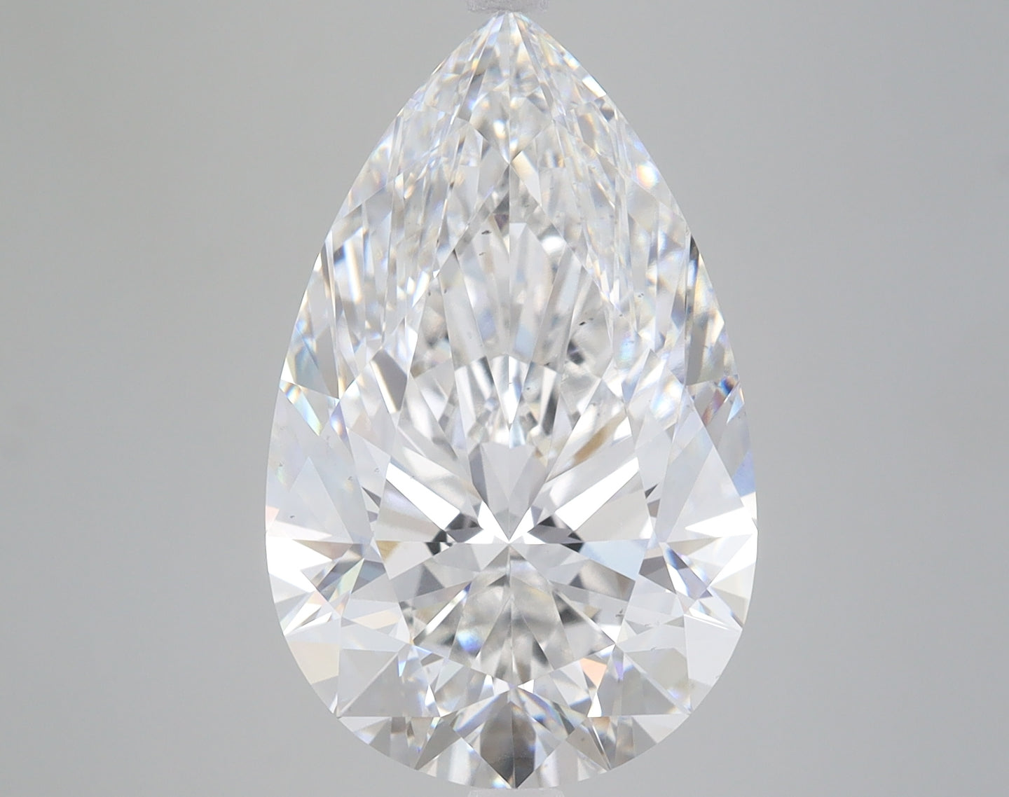Pear-shaped colorless lab-grown diamond with faceted surface and light reflections on neutral background.