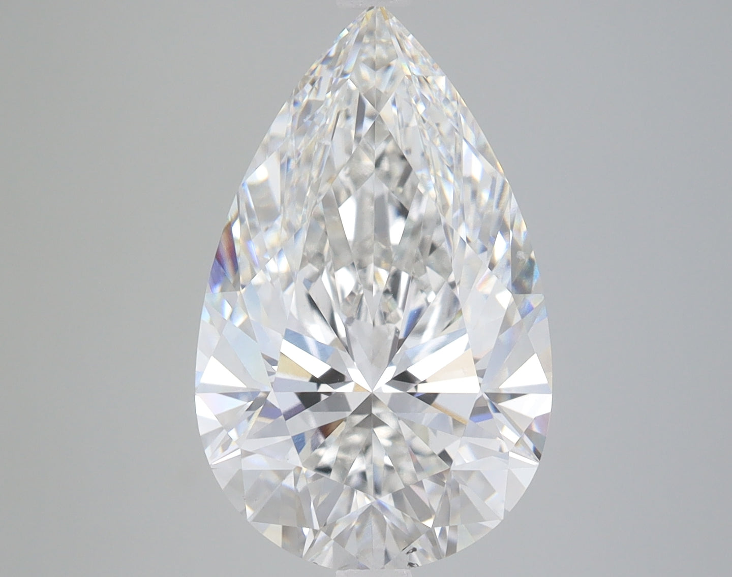 Pear-shaped clear lab-grown diamond with faceted surfaces displaying light refraction, shown against neutral gray background.