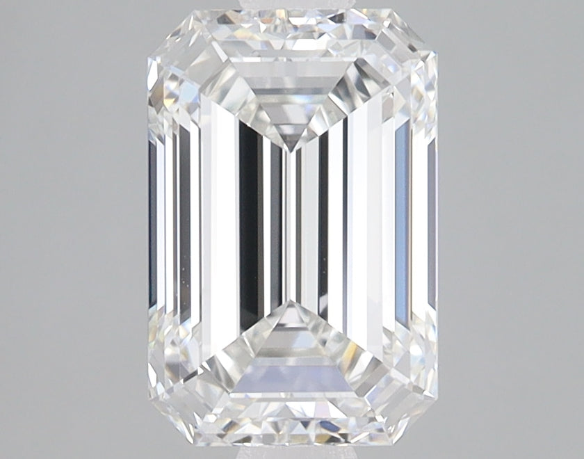Emerald-cut lab-grown diamond with faceted surfaces and clear transparency displayed against a gray background.