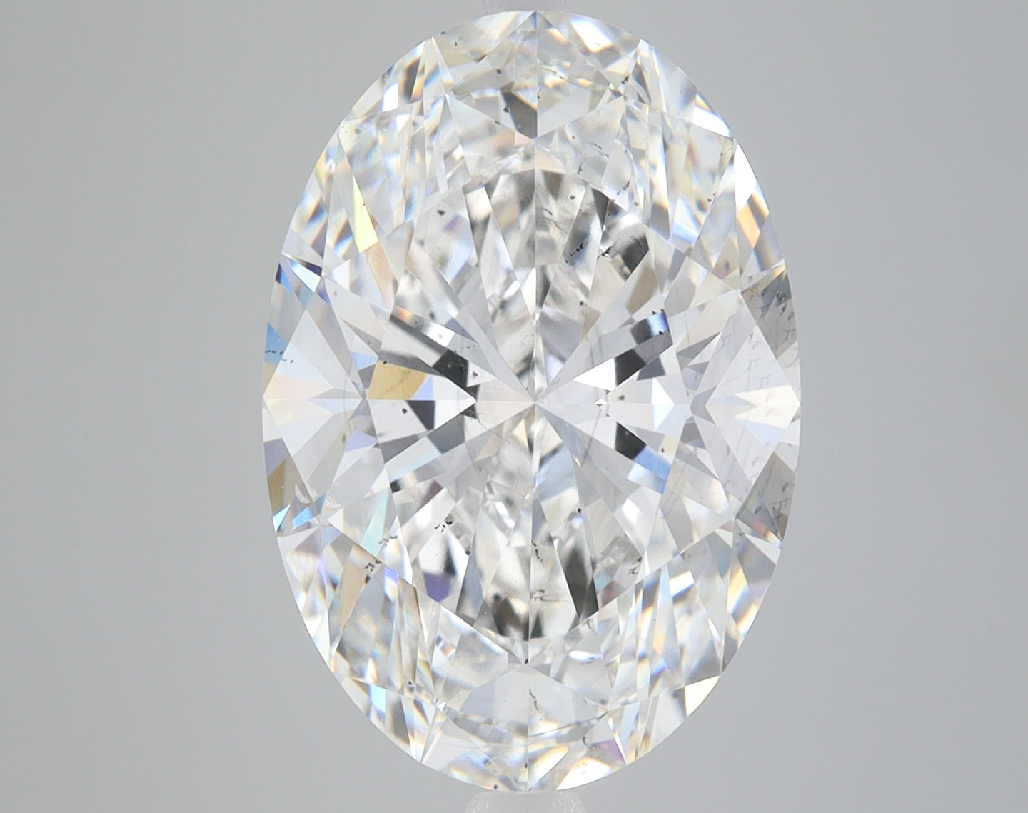 Clear oval-cut lab-grown diamond with brilliant faceting and light refraction on gray background.