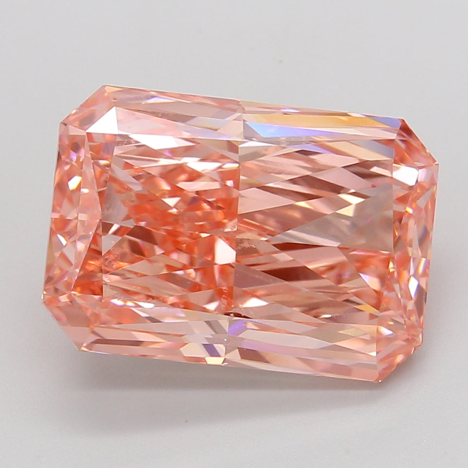 Radiant cut lab-grown diamond with pink-orange coloring and faceted surface reflecting light, displayed against neutral backg