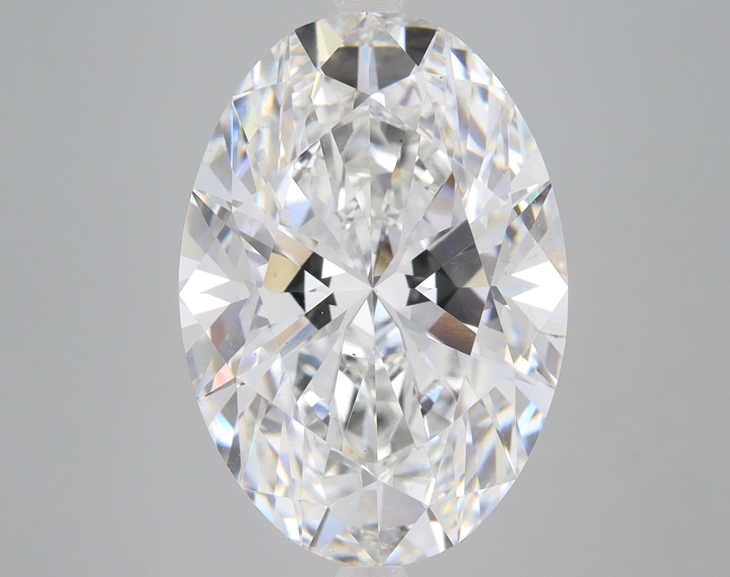 Oval-cut lab-grown diamond with faceted surface reflecting light, displayed against neutral background.