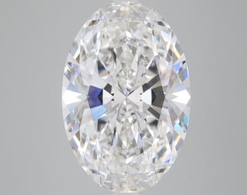 Oval-cut colorless diamond with faceted surface reflecting light, displayed against a neutral gray background.