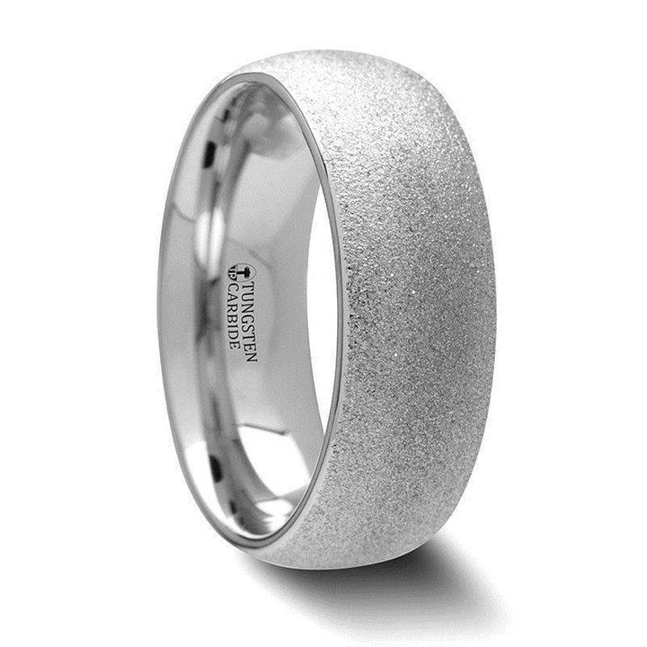 Angled view of a domed tungsten carbide ring with a sparkling sandblasted crystalline finish and polished interior
